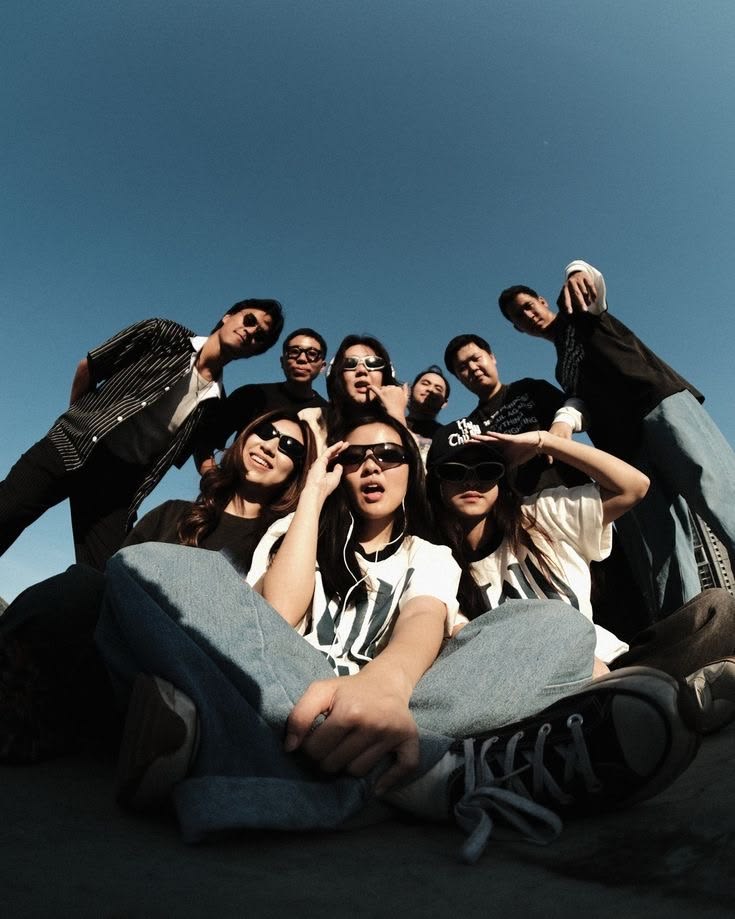 A group of friends photographed together from a low angle beneath a blue sky